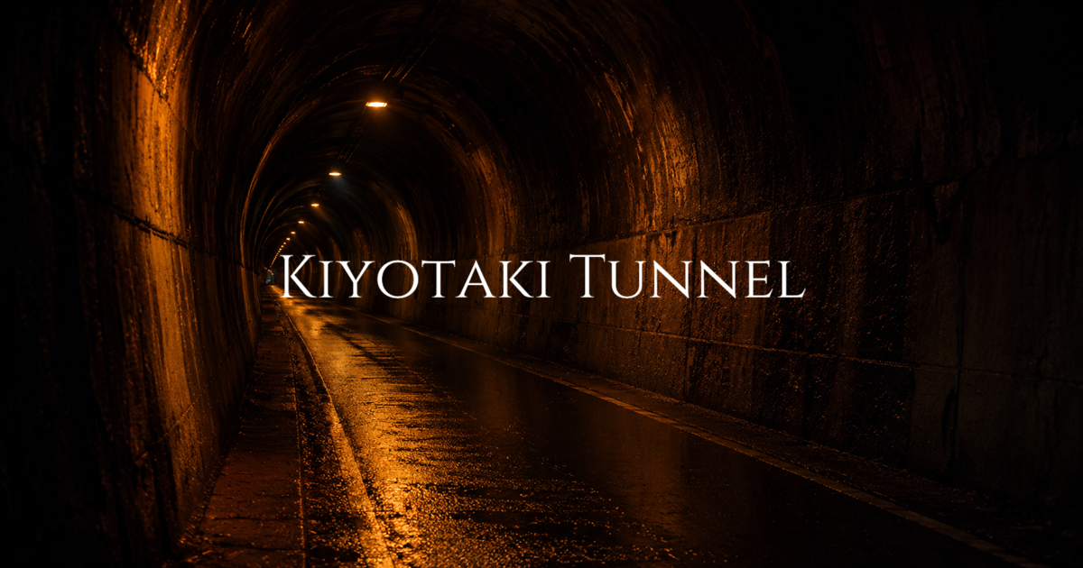 A wet concrete tunnel interior lit by amber lights receding into darkness.